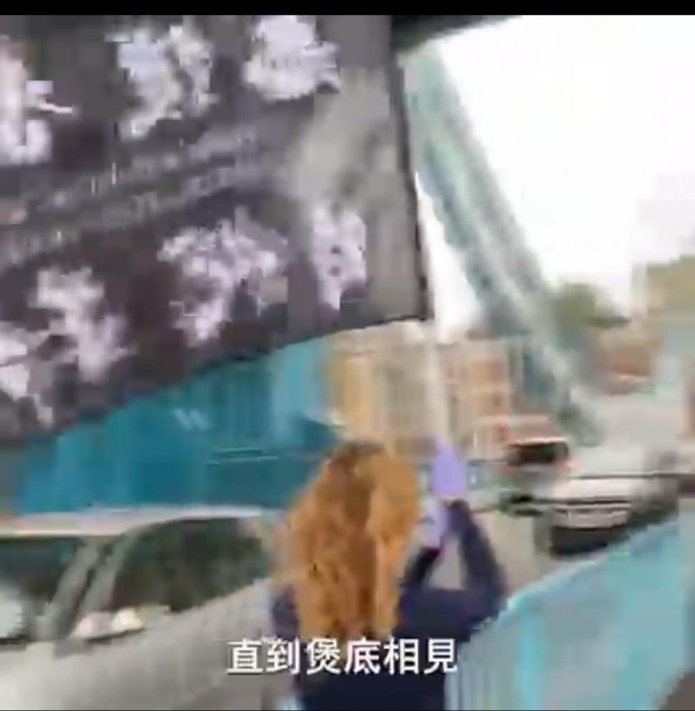 花拉攞住支旗香港黑暴旗遊街，話要「煲底相見」。